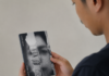 OPINI – Senjata Terakhir Menghadapi Genosida Gaza Seorang pria terlihat dari sisi belakang sedang membaca buku kecil bercover hitam putih bertuliskan Minor Detail karya Adania Shibli. Wajah pria hanya tampak sebagian dalam posisi profil.